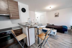 eine Küche und ein Wohnzimmer mit einem Tisch und Stühlen in der Unterkunft Tout confort à Massy - Parking / TGV et RER B&C in Massy