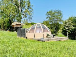 un cenador con un banco en un campo en Les Insolites du Domaine de Suzel en Vignieu