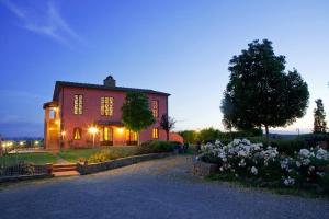 een groot rood huis met lichten aan bij Agriturismo Borgo Vigna Vecchia in Cerreto Guidi