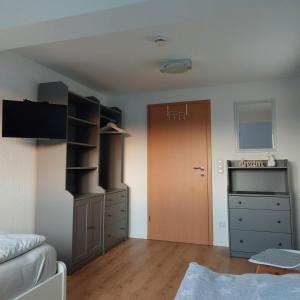 sala de estar con armario y puerta en Ferienwohnung WESERRATTE, en Hameln