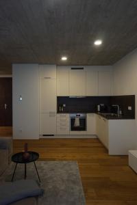 a kitchen with white cabinets and a table in a room at Schönes Neubau Serviced-Apartment mit Parkplatz in Bruchsal