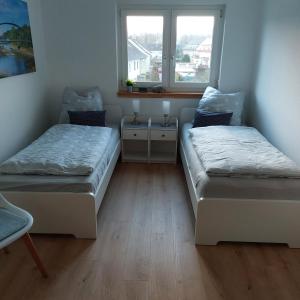 two beds in a room with a window at Ferienwohnung WESERRATTE in Hameln