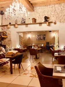 a restaurant with tables and chairs and a stone wall at Les Villas du Domaine de Suzel in Vignieu