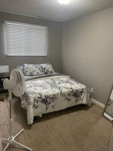 um quarto com uma cama, uma ventoinha e uma janela em Wonderful 2-bedroom apartment em Camrose