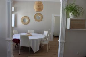 comedor con mesa blanca y sillas blancas en La Casona de Galdós en Las Palmas de Gran Canaria