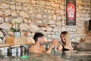 a man and a woman sitting in a bathtub at Les Villas du Domaine de Suzel in Vignieu