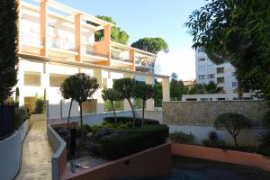 un gran edificio con árboles delante de él en Viva Riviera -14 Avenue Isola Bella, en Cannes
