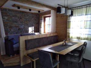 ein Esszimmer mit einem Holztisch und Stühlen in der Unterkunft Martins Comfort Appartement in Assling