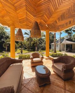 an outdoor patio with chairs and a wooden pergola at Casa Las Palmas Hotel Boutique in San Andrés