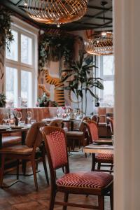 a dining room with tables and chairs and windows at Villa la Vida in Tilburg