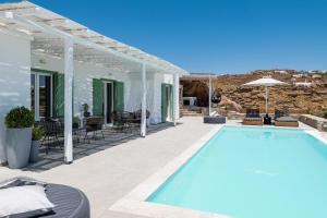 a swimming pool on a patio with a house at Dioni Villa Mykonos in Paraga