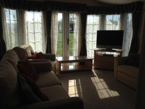 a living room with a couch and a television at Static Caravan (Cliburn Station) in Penrith