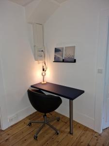 a desk with a chair and a lamp on it at Appartement 2/4 pers Le Cosy in Lons-le-Saunier