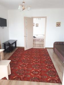 ein Wohnzimmer mit einem roten Teppich und einem Sofa in der Unterkunft Пансионат "Скиф-Мурок" in Bosteri
