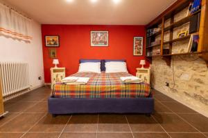 a bedroom with a bed with a red wall at Appartamento Ai Due Pioppi in Lucca