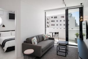 uma sala de estar com um sofá e um quarto em The Flamingo Private Apartments by Perch Stays na Cidade do Cabo