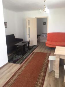 ein Wohnzimmer mit einem roten Sofa und einem Tisch in der Unterkunft Пансионат "Скиф-Мурок" in Bosteri