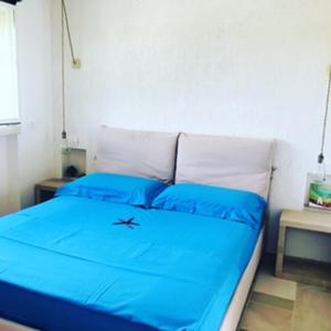 1 dormitorio con 1 cama azul y 2 almohadas azules en RIFUGIO Salentro, en Botrugno