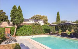 einen Pool mit 2 Stühlen und einem Sonnenschirm in der Unterkunft Stunning Home In Boure With Outdoor Swimming Pool in Saint-Brice
