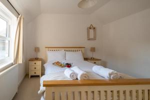 una camera da letto con un letto con asciugamani sopra di The Pink House, Aldeburgh ad Aldeburgh