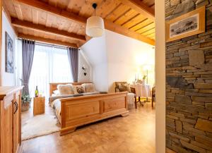 a living room with a couch and a stone wall at Willa Mały Dworek in Zakopane