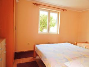 a bedroom with a bed and a window at Apartmani Sindik in Tivat
