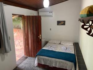 Habitación pequeña con cama y puerta en Pousada e Camping Lumiar en Lençóis