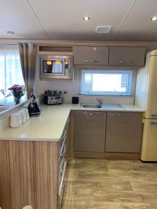 a small kitchen with a sink and a refrigerator at Glade 50 Bideford Bay Holiday Park in Bideford