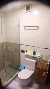 a bathroom with a toilet and a glass shower at Hotel Blue Malecón And Spa in Santo Domingo +44 photos