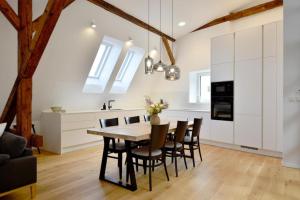 cocina y comedor con mesa de madera y sillas en Apartmán 1901, en Trenčín