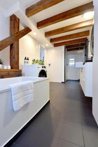 a large kitchen with white appliances and a large room at Apartmán 1901 in Trenčín