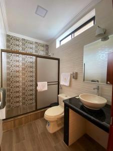 a bathroom with a toilet and a sink at Hostal California Inn in Guayaquil