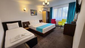 a hotel room with two beds and a table and chairs at Turquoise Konak in Eforie Sud