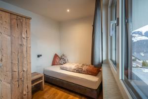 a small bedroom with a bed and a window at Luxapart Haus 2 in Ladis