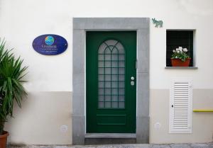 una porta verde sul lato di un edificio bianco di Casagiugiù a Vietri
