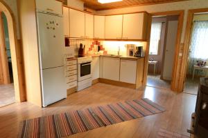 a kitchen with white appliances and a wooden floor at Wismens Natur & Fiske in Krogsered