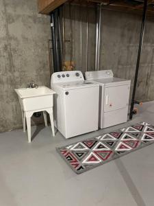 een keuken met een wasmachine en een wastafel bij Cozy Home in Camrose