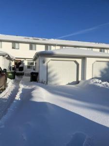 une maison avec beaucoup de neige devant elle dans l'établissement Cozy Home, à Camrose
