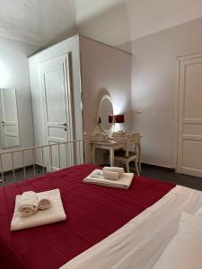 ein Schlafzimmer mit einem Bett mit zwei Handtüchern und einem Spiegel in der Unterkunft Etna Rooms in Catania