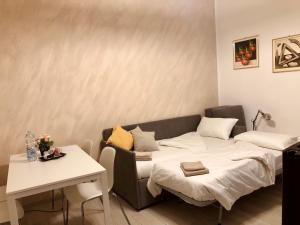 uma sala de estar com uma cama e uma mesa em Lovely 2 room apartment with small garden em Milão