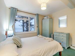 a bedroom with a large white bed and a window at Sea Breeze - Mount Brioni in Downderry
