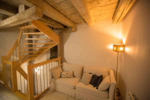ein Wohnzimmer mit einem Sofa und einer Treppe in der Unterkunft La grange de Sophie in Berstett