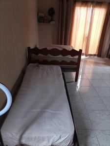a bed sitting in a room with a window at Recanto da Paz in Solemar