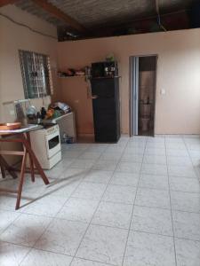 a kitchen with a white tiled floor and a table at Recanto da Paz in Solemar