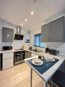 斯托克波特New Studio Apt Central》Private》 Free Parking》WiFi的厨房配有带盘子和酒杯的桌子