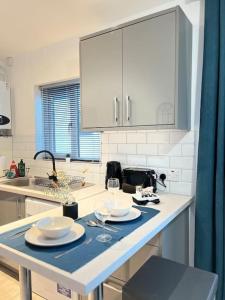 斯托克波特New Studio Apt Central》Private》 Free Parking》WiFi的厨房配有带盘子和酒杯的桌子 更多20张照片