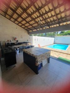 a kitchen with a table and a swimming pool at Casa para Temporada Praia Grande in Fundão