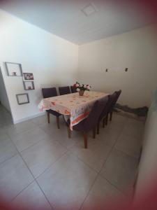 a dining room with a table with chairs and flowers on it at Casa para Temporada Praia Grande in Fundão