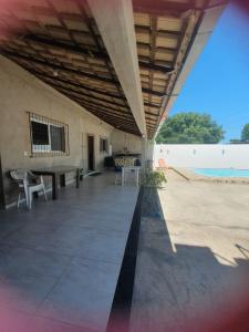 a patio with a table and chairs on the beach at Casa para Temporada Praia Grande in Fundão