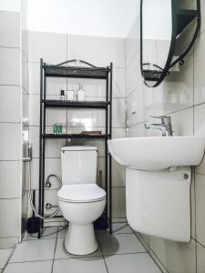 a bathroom with a white toilet and a sink at Modern Apartment - Work from Zanzibar (Fumba Town) in Dambani